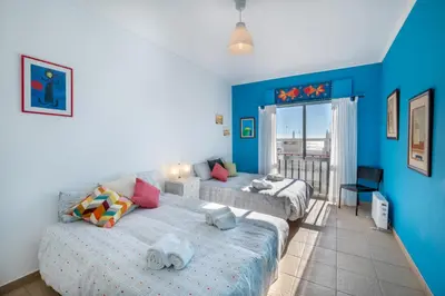 a bedroom with two beds and a blue wall at Vita Portucale ! Quarteira Sea View in Quarteira