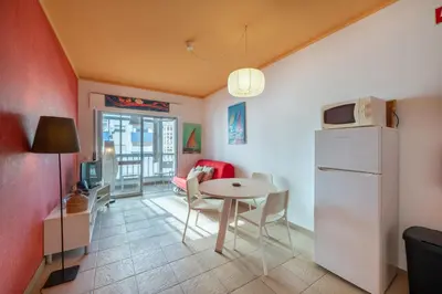 a kitchen and dining room with a table and a refrigerator at Vita Portucale ! Quarteira Sea View in Quarteira