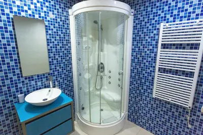 a blue tiled bathroom with a shower and a sink at Marina Vilamoura - Aquamar 320 by Vilamoura Sun in Vilamoura