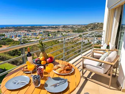 a table with food on a balcony with a view at AlbufeiraOrada by Be Cherish in Albufeira