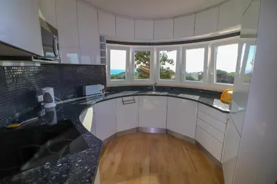 a kitchen with black and white counters and windows at Santa Eulalia Mar in Albufeira