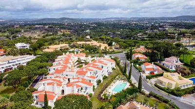 a swimming pool with lounge chairs and an umbrella at Vale do Lobo - Casa de La Rosa in Vale do Lobo
