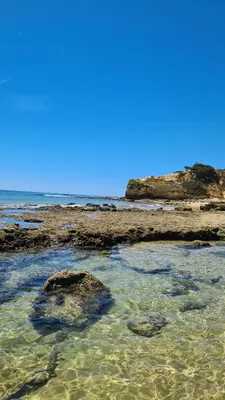 a group of rocks in the water on a beach at Vista das Ondas in Albufeira