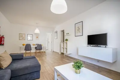 a living room with a couch and a tv on a wall at #002 Donalds Flat by Home Holidays in Albufeira