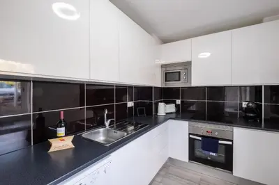 a kitchen with white cabinets and a sink at #002 Donalds Flat by Home Holidays in Albufeira