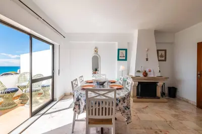 a dining room with a table and a fireplace at Casa Cerro Branco in Albufeira