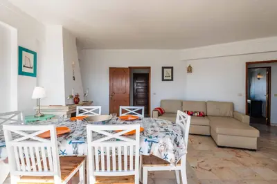 a living room with a table and chairs and a couch at Casa Cerro Branco in Albufeira