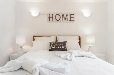 a white bedroom with a bed with a home sign above it at Fisherman's Beach Home 2BR 2BA AC Wi-Fi in Albufeira