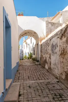 an alley with an archway between two buildings at Fisherman's Beach Home 2BR 2BA AC Wi-Fi in Albufeira
