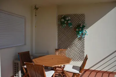 a wooden table and chairs in a room at Balcony View Albufeira in Albufeira
