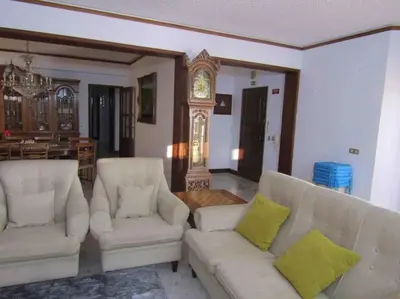 a living room with two white couches and a clock at Apartamento Sao Jose in Albufeira