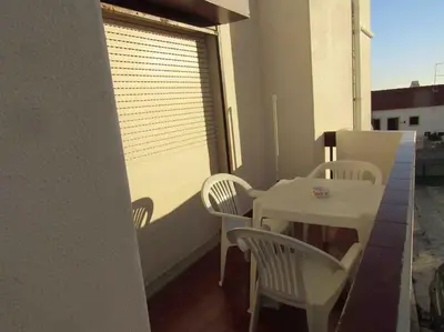 a white table and chairs on a balcony at Apartamento Sao Jose in Albufeira
