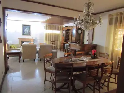 a dining room and living room with a table and a piano at Apartamento Sao Jose in Albufeira
