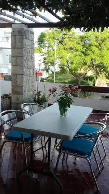 a white table and chairs with a vase on it at Apartamento Sao Jose in Albufeira