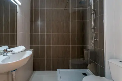 a bathroom with a shower and a sink and a toilet at Apartments near Marina de Vilamoura in Quarteira