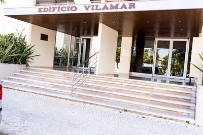 a building with stairs in front of a building at Apartments near Marina de Vilamoura in Quarteira