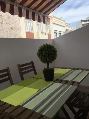 a table with a potted tree sitting on a balcony at Casa Da Baixa in Faro