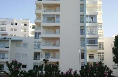 an apartment building with balconies and trees at COLINA FÉRIAS- Garagem & WIFI in Quarteira