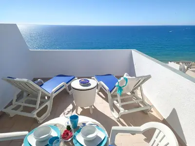 a table and chairs on a balcony with the ocean at Mira Atlântico 13- Terraço Com Vista Mar e Cidade, Wifi, 80mt Praia in Quarteira