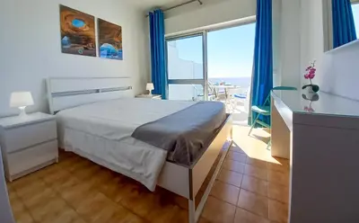 a bedroom with a bed and a view of the ocean at Mira Atlântico 13- Terraço Com Vista Mar e Cidade, Wifi, 80mt Praia in Quarteira