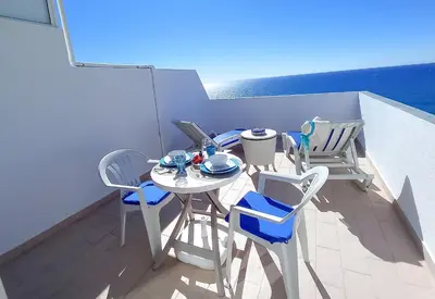 a balcony with a table and chairs on a roof at Mira Atlântico 13- Terraço Com Vista Mar e Cidade, Wifi, 80mt Praia in Quarteira