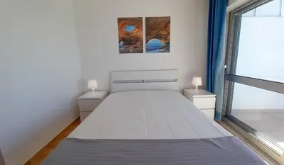 a white bed in a room with a window at Mira Atlântico 13- Terraço Com Vista Mar e Cidade, Wifi, 80mt Praia in Quarteira