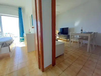 a living room with a table and a dining room at Mira Atlântico 13- Terraço Com Vista Mar e Cidade, Wifi, 80mt Praia in Quarteira