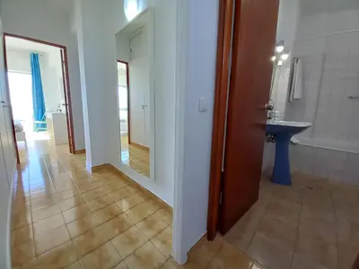a hallway of a bathroom with a sink and a mirror at Mira Atlântico 13- Terraço Com Vista Mar e Cidade, Wifi, 80mt Praia in Quarteira
