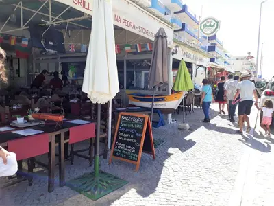 a market with umbrellas and people walking on a street at Pontemira 5 Esplêndido in Quarteira