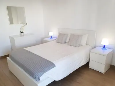 a bedroom with a white bed with two night stands at Pontemira 5 Esplêndido in Quarteira