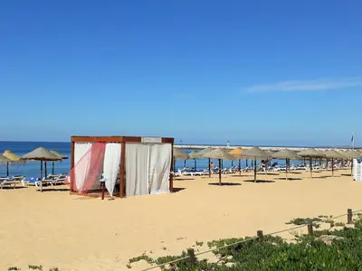 a beach with umbrellas and chairs and the ocean at Torre Azul 11 Vista Panoramica in Quarteira