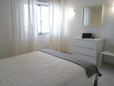 a bedroom with a bed and a dresser and a window at TORRE 14 Vista Magnifica in Quarteira