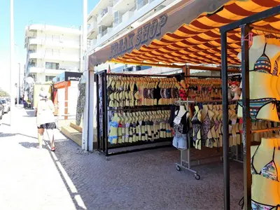 a woman standing in front of a store with a rack of shoes at TORRE 14 Vista Magnifica in Quarteira