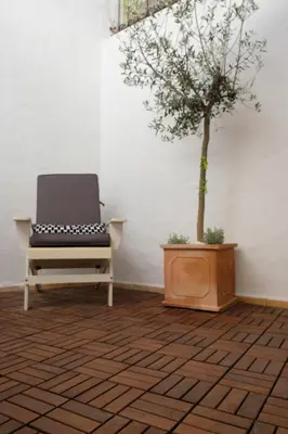 a chair sitting next to a tree in a room at Yellow House - Checkinhome in Boliqueime