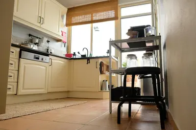 a kitchen with a black chair and a counter at Yellow House - Checkinhome in Boliqueime