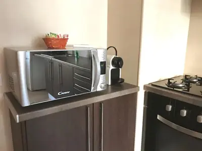 a microwave sitting on top of a counter next to a stove at cosy2bedroomapartment in Loulé