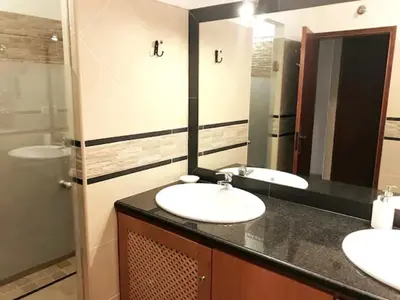 a bathroom with two sinks and a large mirror at cosy2bedroomapartment in Loulé