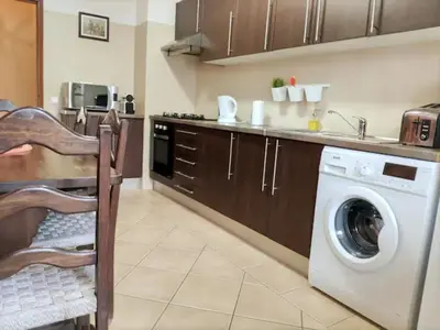 a kitchen with a washing machine and a sink at cosy2bedroomapartment in Loulé