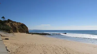 a sandy beach with a view of the ocean at Apartamentos Cabrita in Olhos de Água