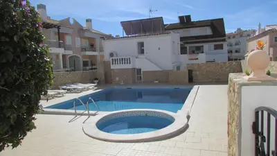 a swimming pool in the middle of a yard with buildings at Apartamentos Cabrita in Olhos de Água
