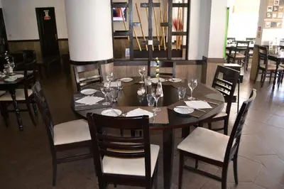 a dining room with a wooden table and chairs at Apartamentos Cabrita in Olhos de Água