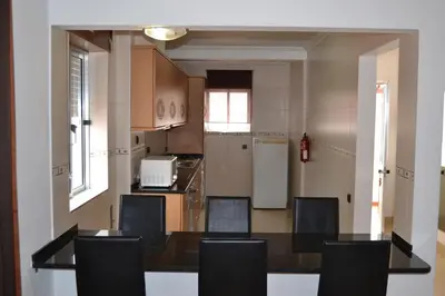 a kitchen with a dining room table and chairs at Apartamentos Cabrita in Olhos de Água