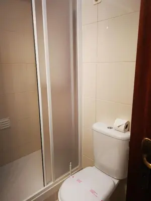 a small bathroom with a toilet and a shower at Mira Parque in Albufeira