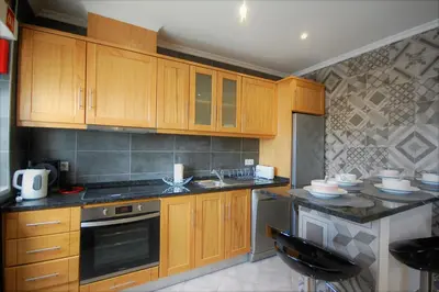 a kitchen with wooden cabinets and a counter top at Vila Baltum - Free private parking - Wifi - Airco # by bedzy # in Albufeira