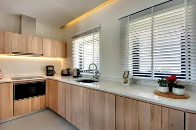 a kitchen with wooden cabinets and a sink at Casa Indigo- Perfect location & Sea View by DreamvillasAlbufeira in Albufeira
