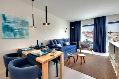 a living room with a blue couch and a table at Casa Indigo- Perfect location & Sea View by DreamvillasAlbufeira in Albufeira