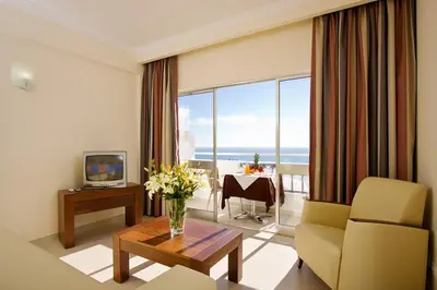 a living room with a couch and a table with a television at Silmar in Albufeira