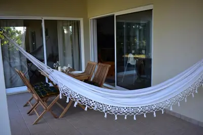 a hammock on a patio with a table and chairs at FIND Your Space Casa no Campo - Paderne - Albufeira - Piscina Privada - Aquecida a pedido in Paderne