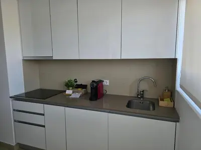a kitchen counter with a sink and white cabinets at Cavalo Preto Luxury Beach Resort - C201 in Quarteira