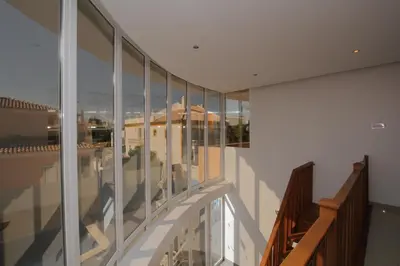 a balcony of a building with glass windows at Full private 300sqm Villa Jacuzzi Heated Pool Ideal & quiet location in Albufeira